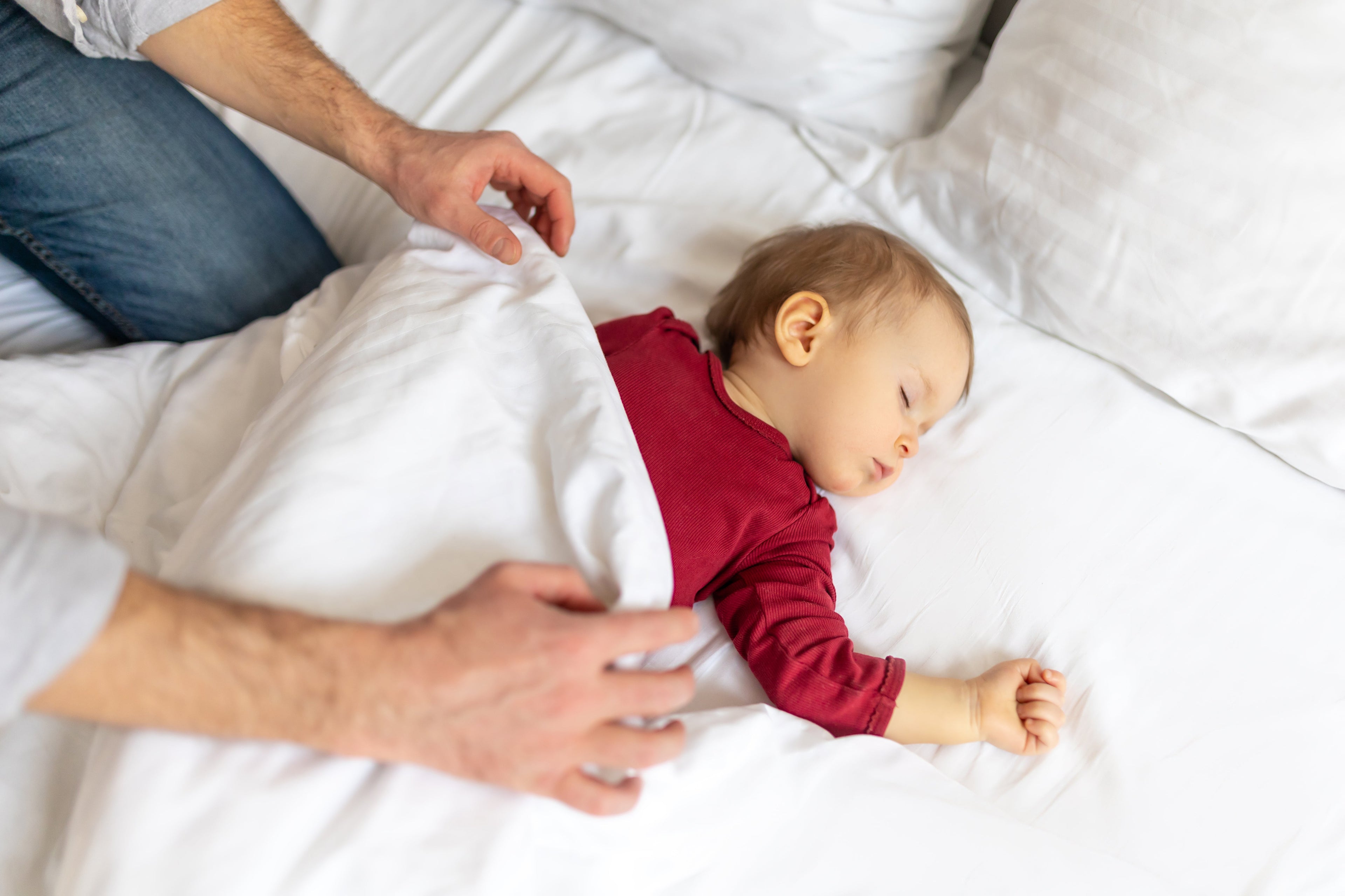 Bébé de 12 mois debout dans son lit pendant une régression du sommeil