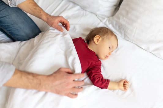Bébé de 12 mois debout dans son lit pendant une régression du sommeil